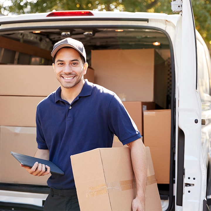 FET Kurierfahrer beim Zustellen – Europaweite Express- und Sonderfahrten Ein FET Kurierfahrer liefert Pakete aus einem Transporter – zuverlässige Abholung und Zustellung in Deutschland und ganz Europa, rund um die Uhr.