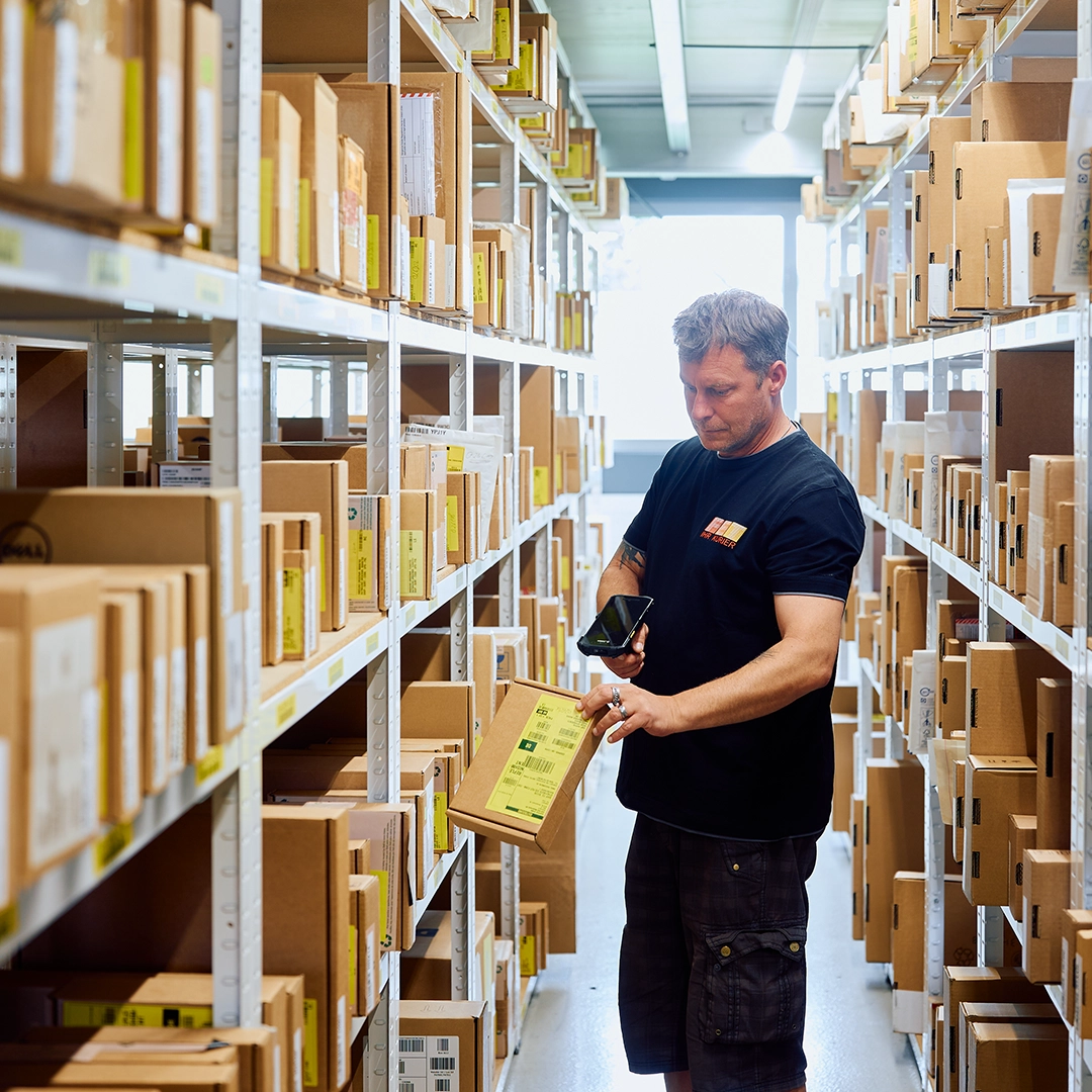 FET Lagerung – Flexible Lagerlösungen und 24h-Service in Europa Ein FET Mitarbeiter prüft gelagerte Pakete in einem Regal – flexible Lagerung, Handverladung und High-Emergency-Lager mit europaweitem 24h-Service.